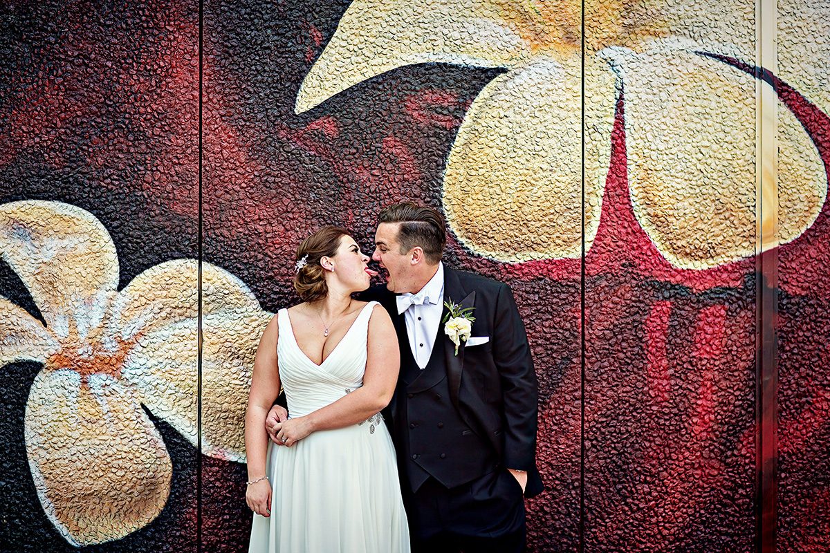 Bride and groom messing around at Shoreditch wedding by graffiti