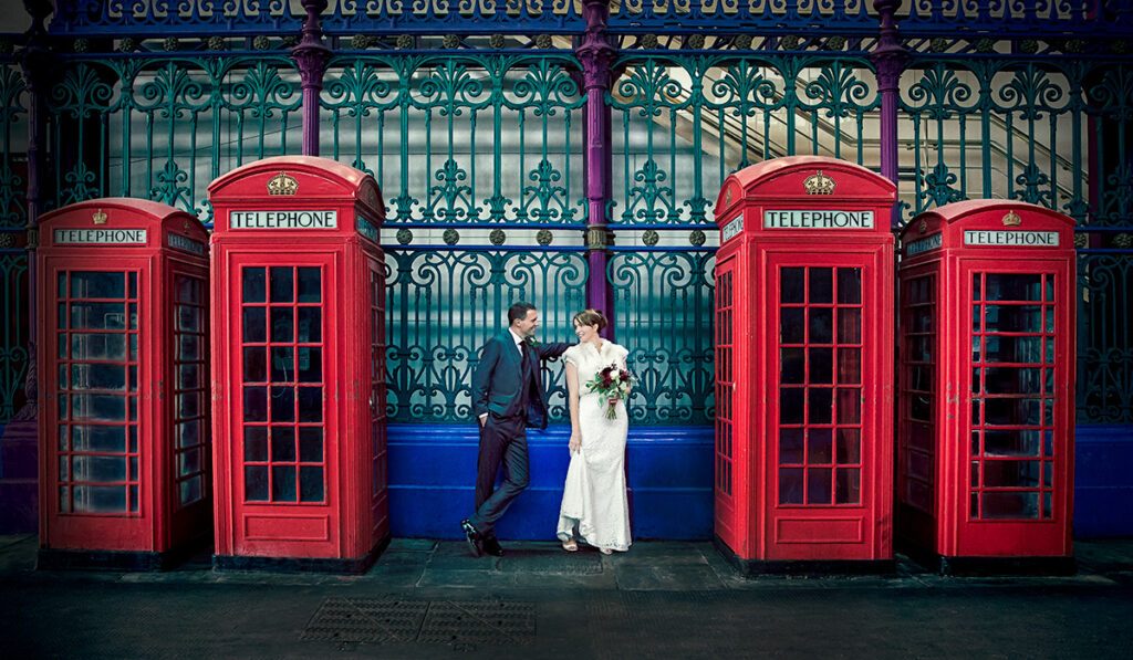 Couple by red phone boxes London wedding day Smithfield
