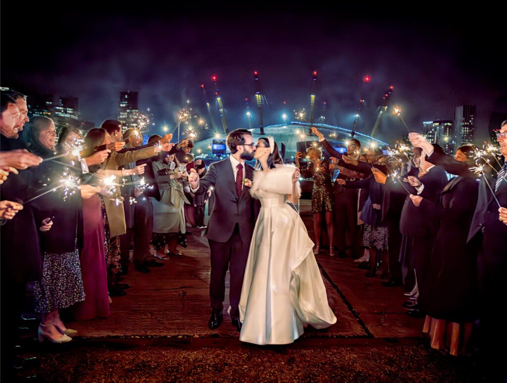 Trinity Buoy Wharf wedding sparklers with bride and groom kiss two