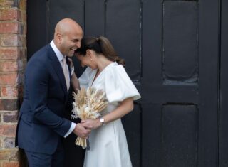 Bride and groom laugh by St Albans Registry doors