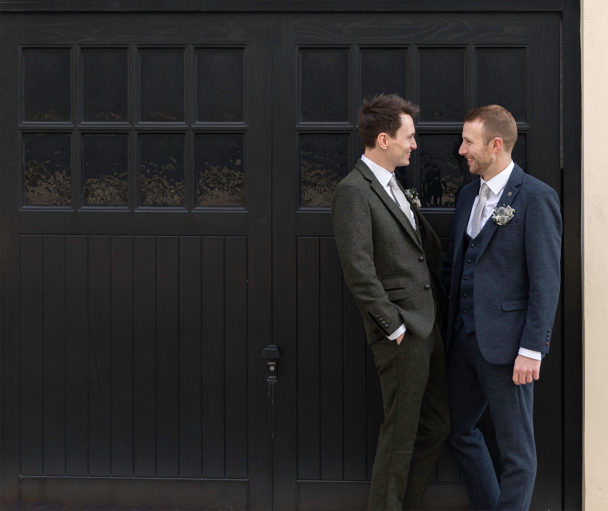 Groom and groom by black doors Marylebone wedding