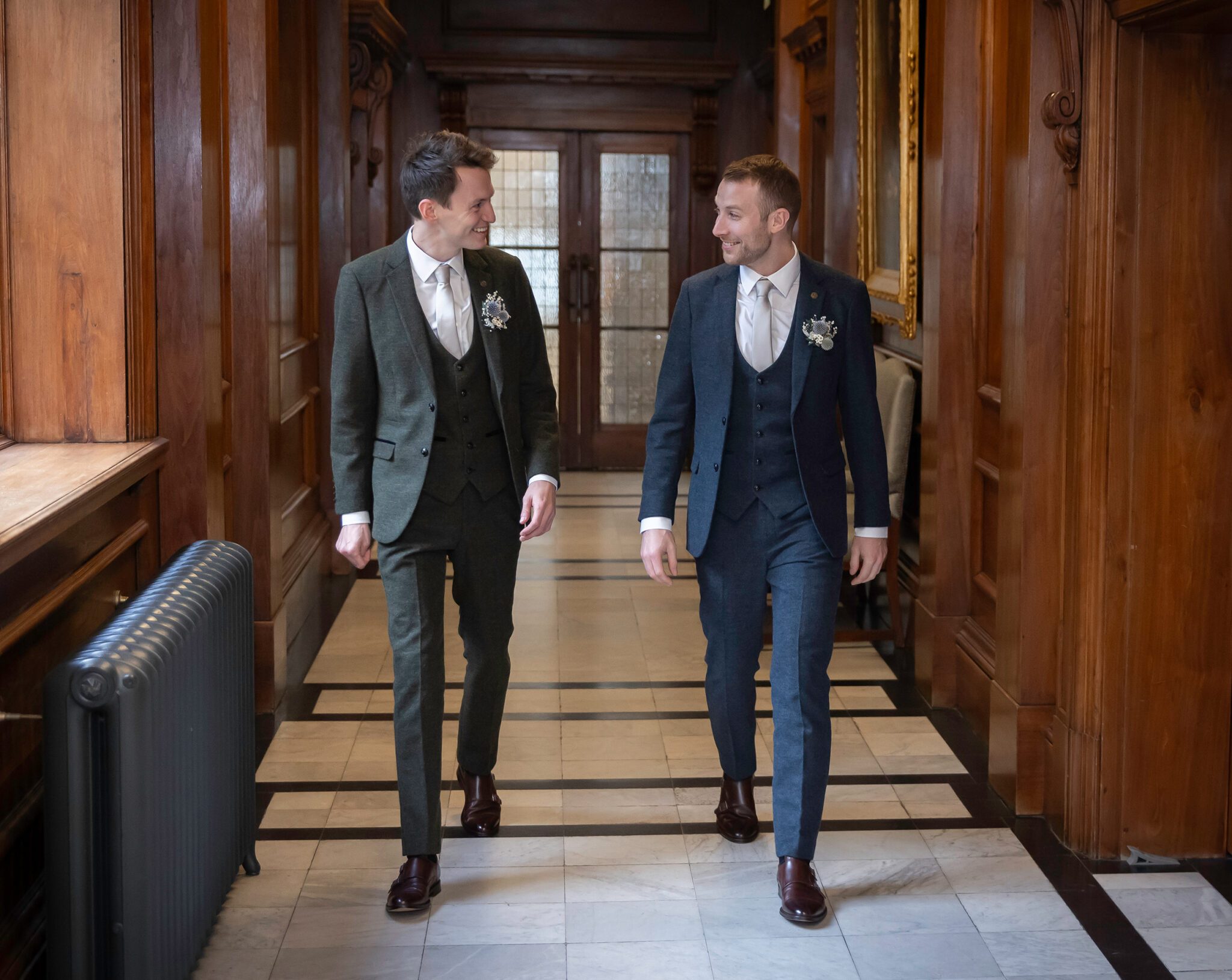 Grooms walk through Old Marylebone Town Hall corridors at wedding