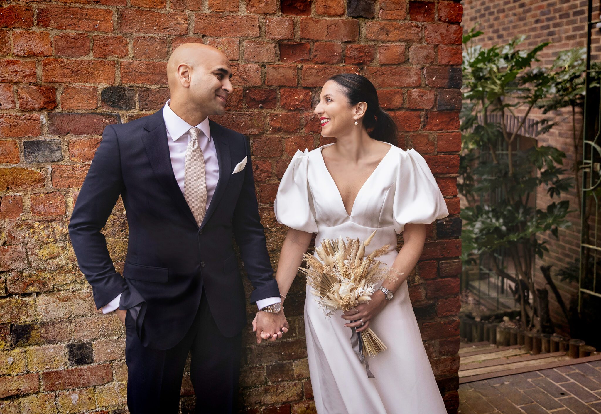 St Albans wedding couple by wall hand in hand