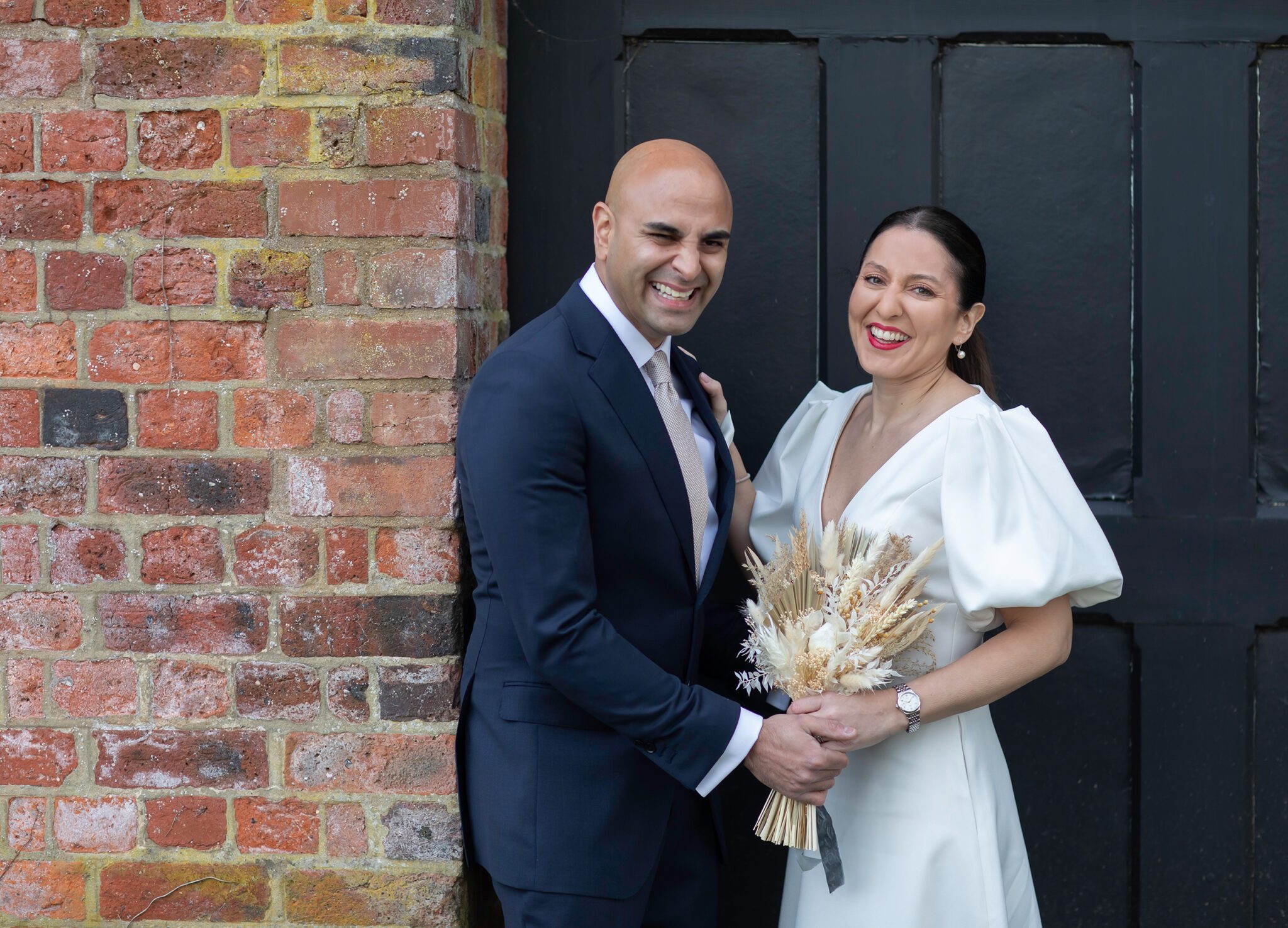 Wedding-couple-laughing-at-St-Albans-Registry-office-gates