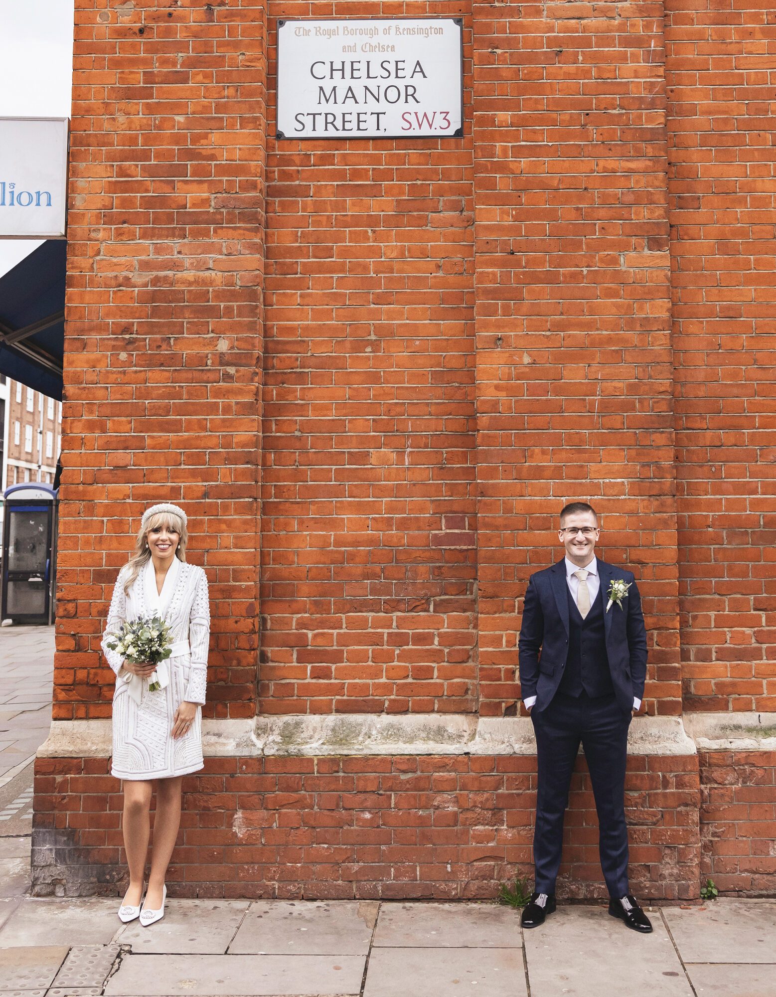 Bride and groom by wall at Chelsea Old Town Hall Wedding