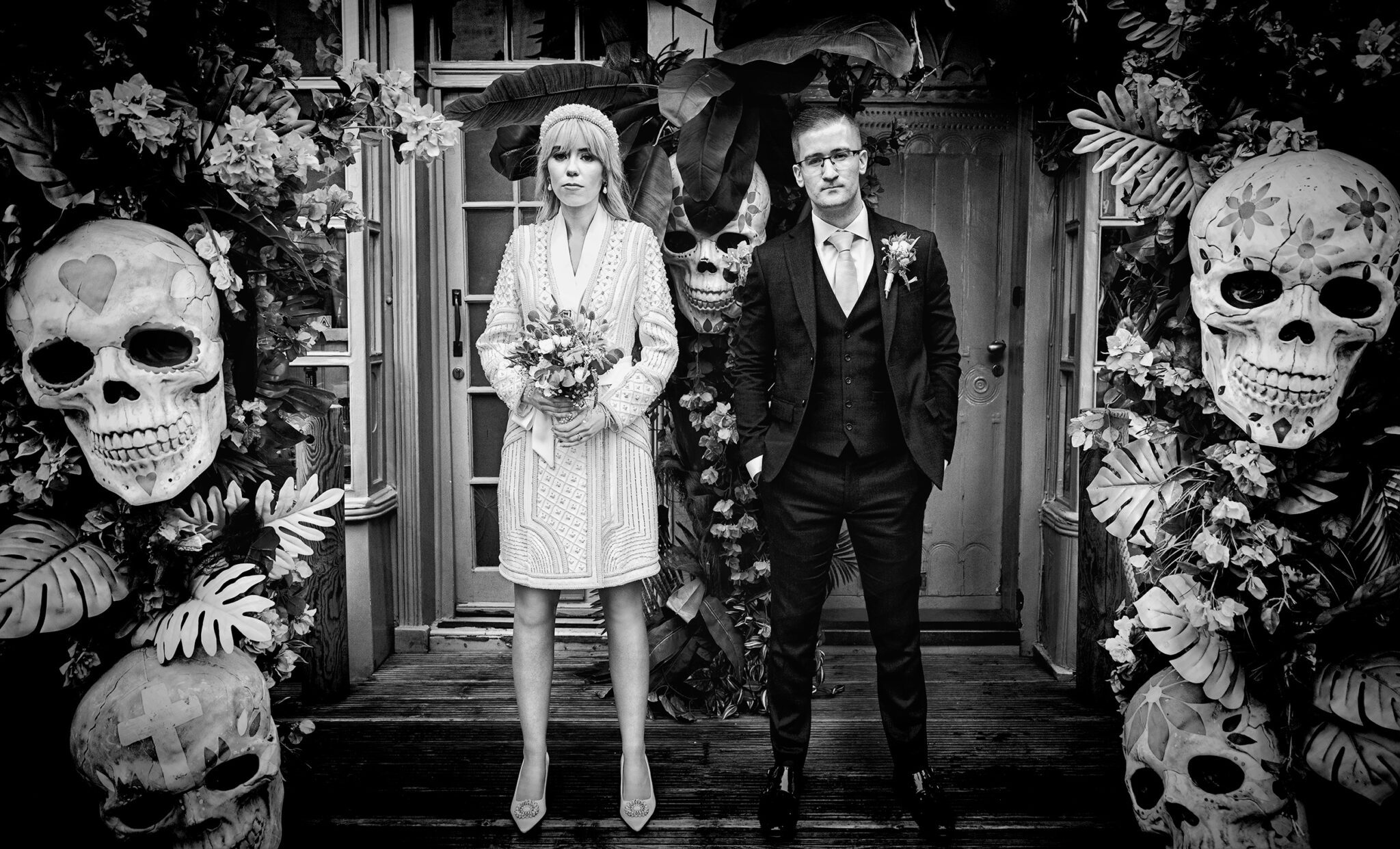 Chelsea Old Town Hall Wedding couple stand by Mexican skulls Kings Road BW