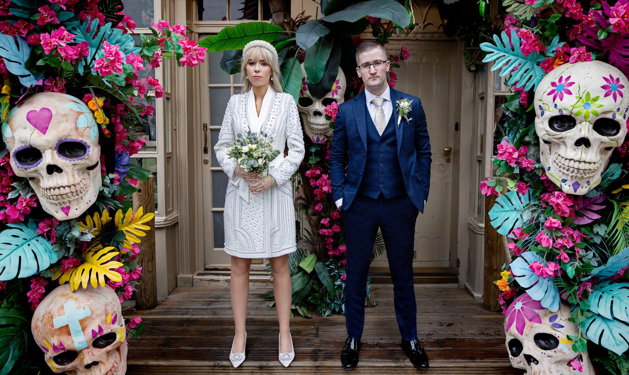Chelsea Old Town Hall Wedding couple stand by Mexican skulls Kings Road