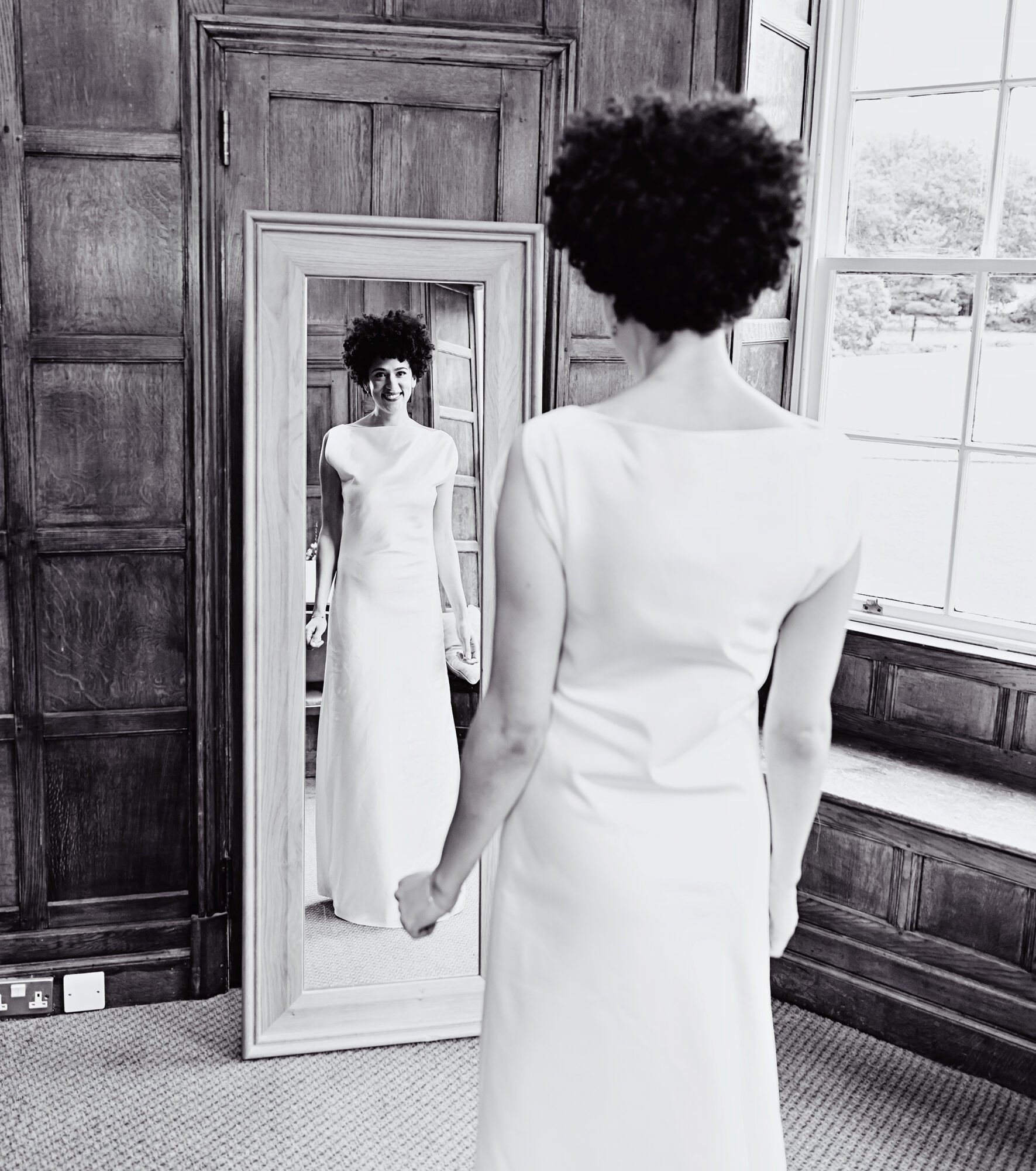 Bride looks in mirror Wotton House wedding morning