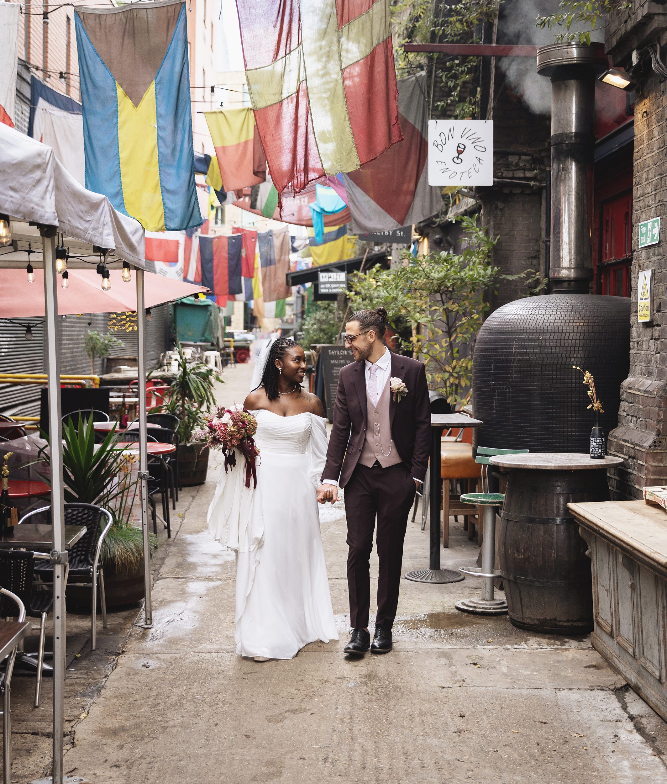 Bride and groom walk through Maltby Street Market