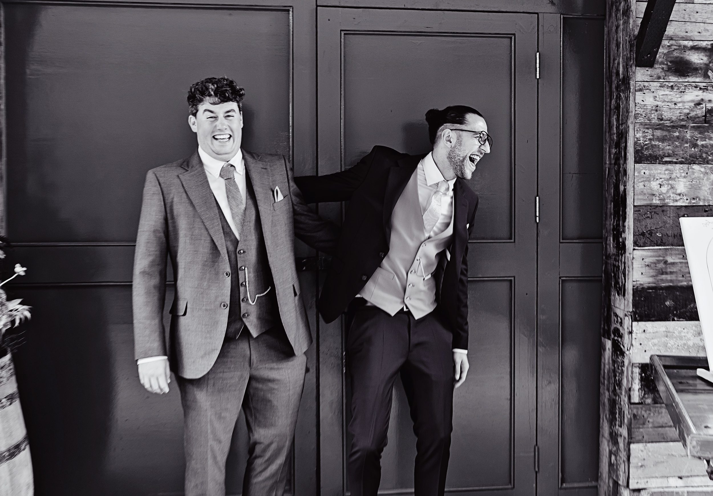 Groom and best man laugh outside Old Timber Store Wedding