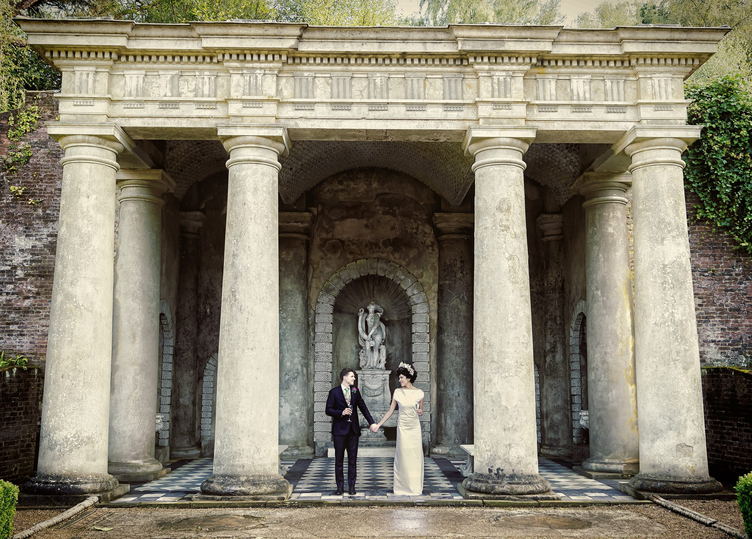 Bride and groom between pillars Wotton House wedding