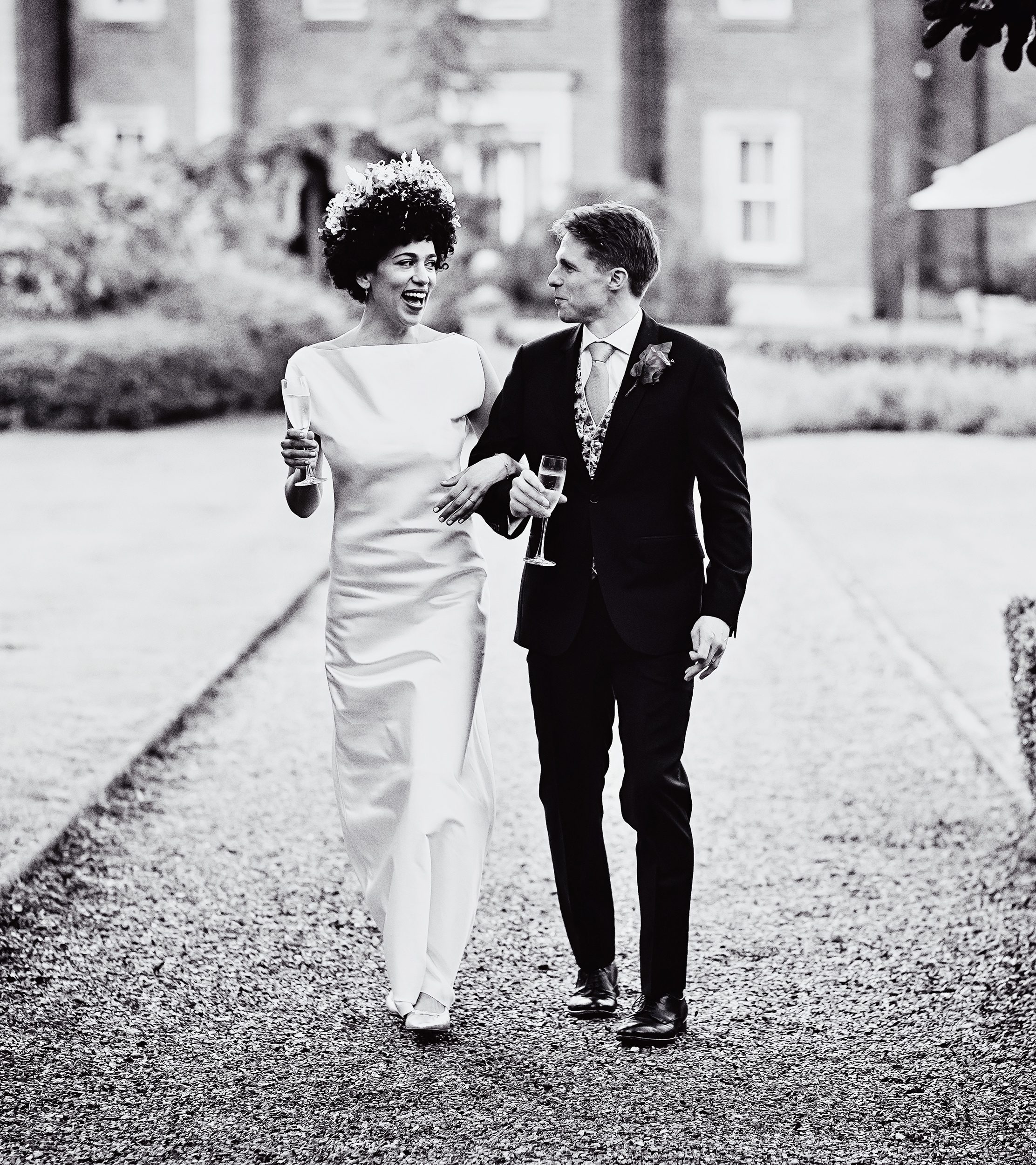 Bride and groom walk through grounds together Wotton House