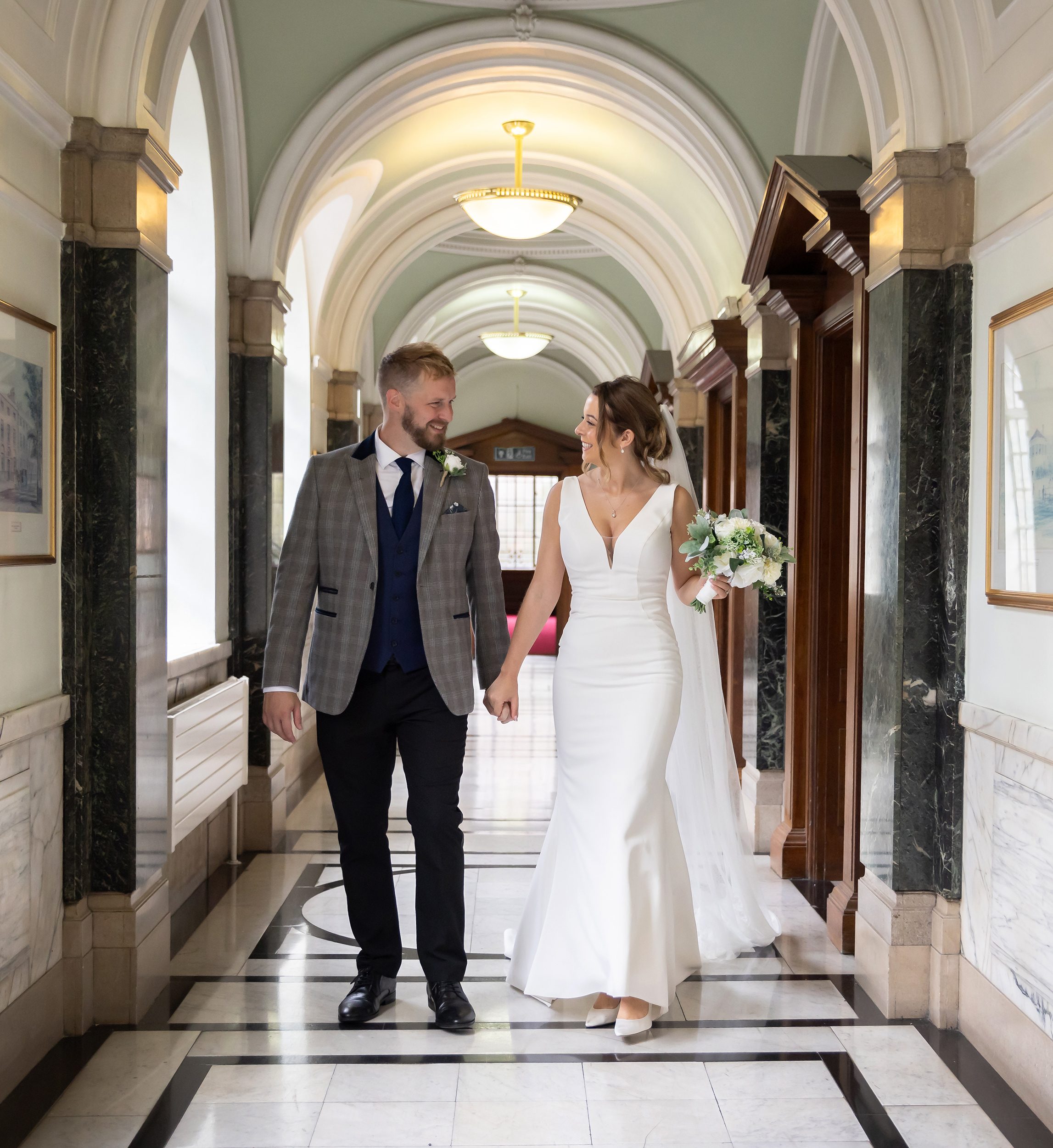 Bride and groom walk down corridor Islington Town Hall wedding