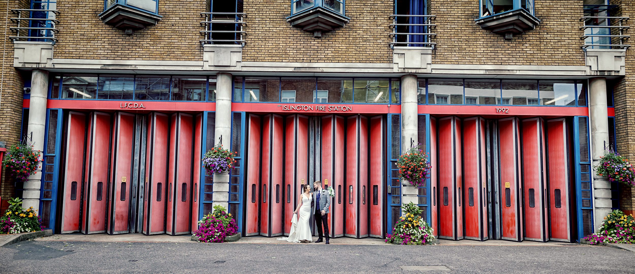 Islington Town Hall Wedding couple outside Fire Station wide shot