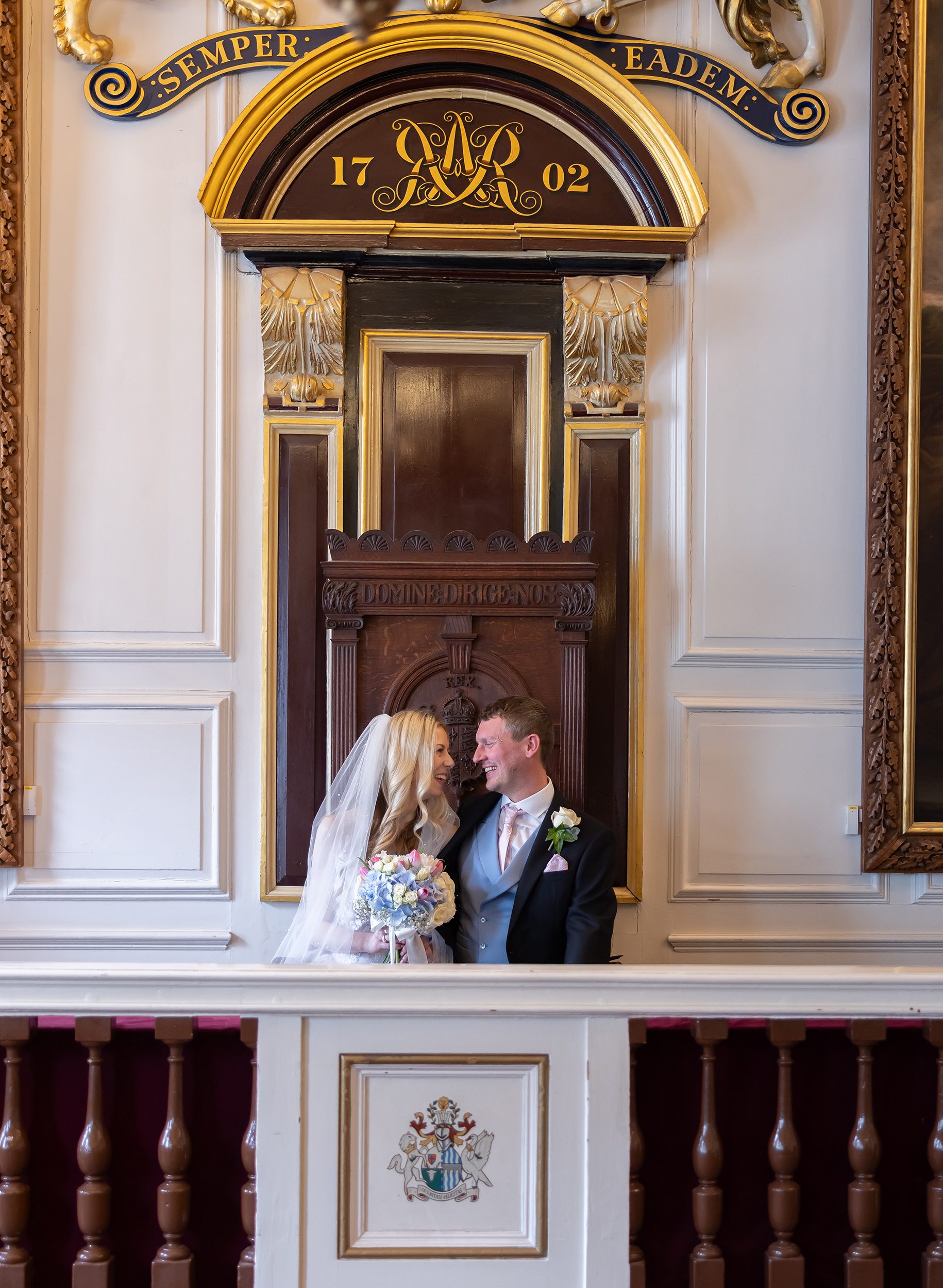 Bride and groom sit laughing in Windsor Guildhall wedding room