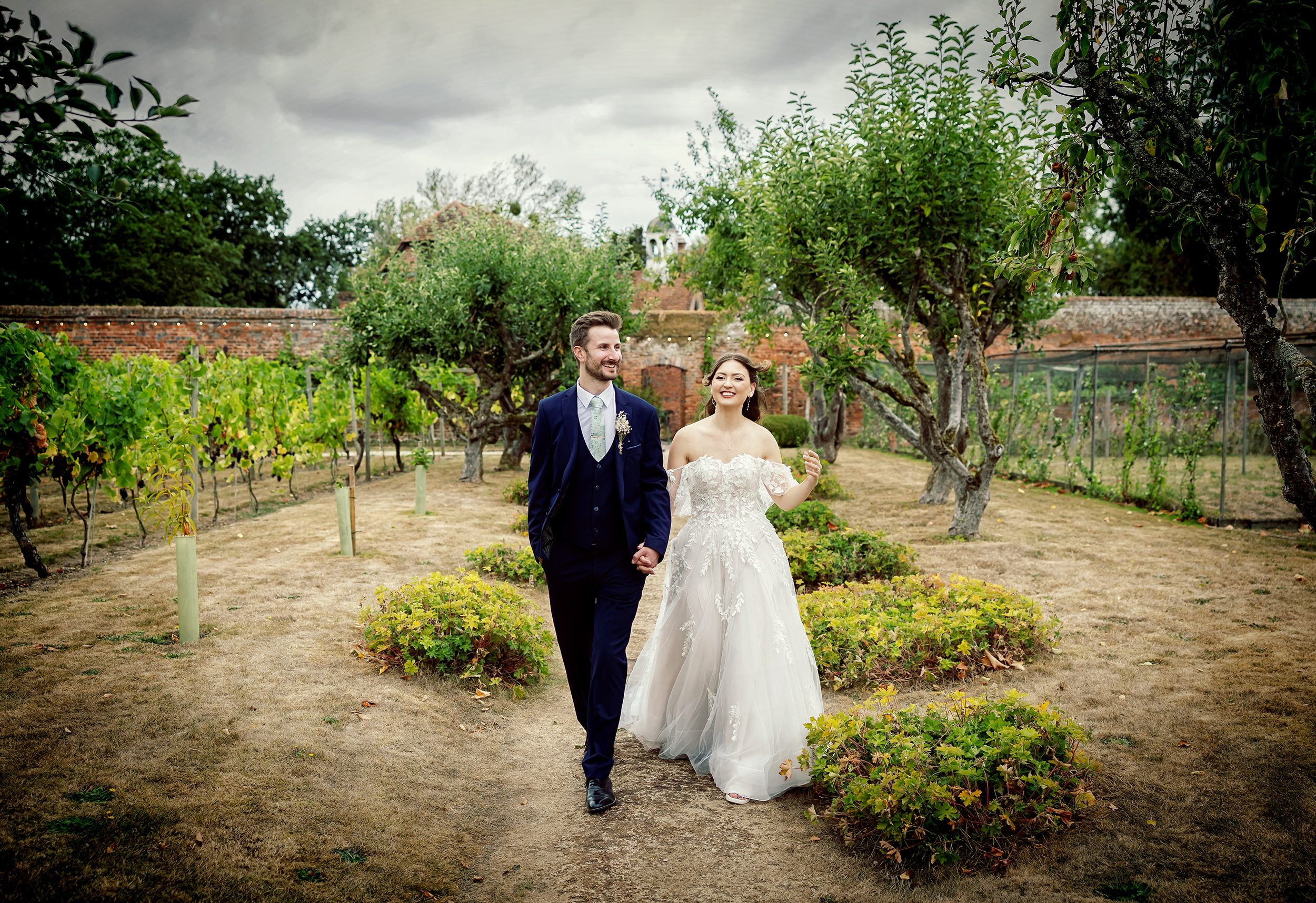 Bride and groom walk through vines at Stanlake Park Wedding