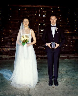 London wedding couple with old camera Lodge Farm barn