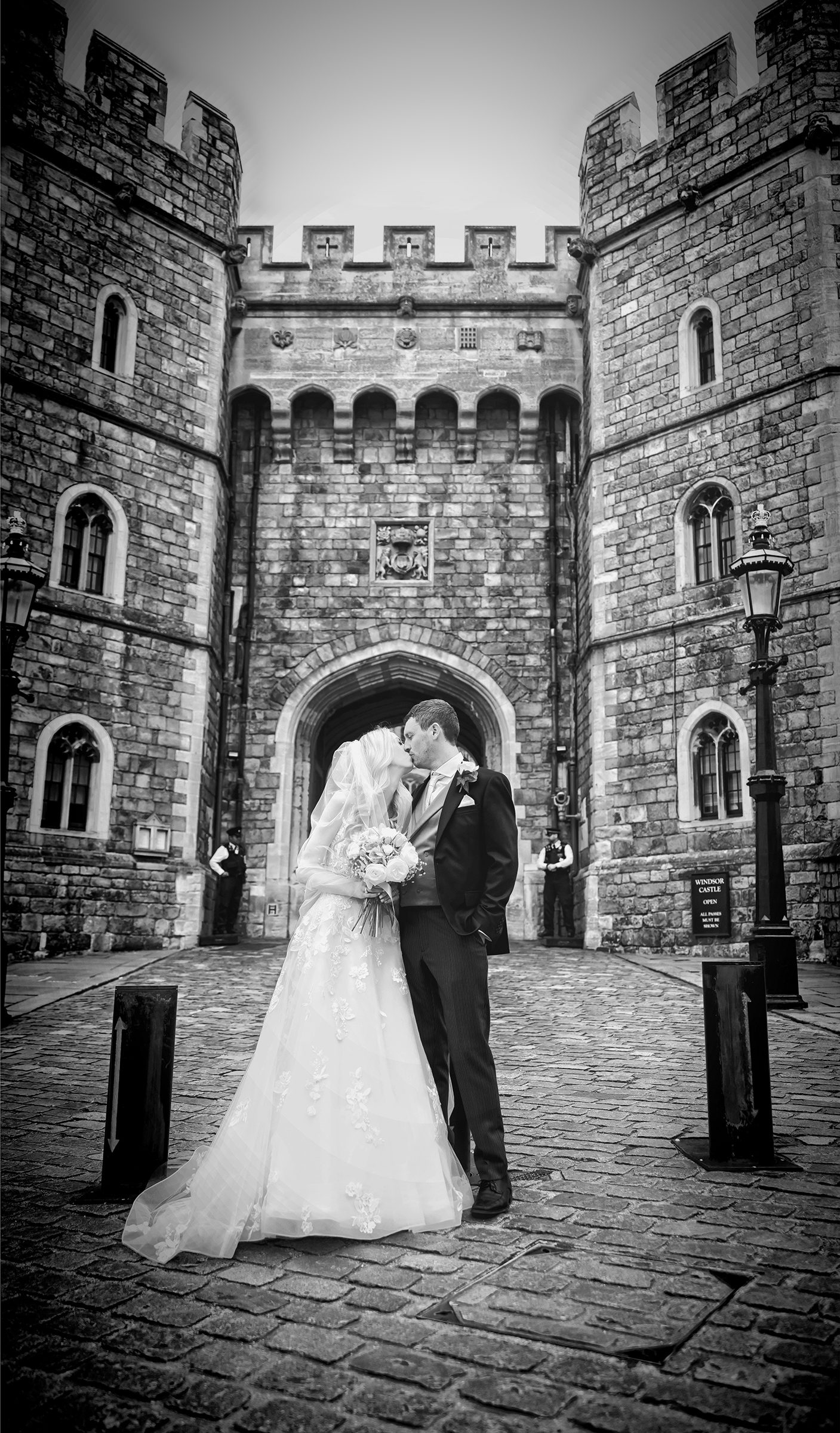 Wedding couple kiss outside Windsor Castle black and white