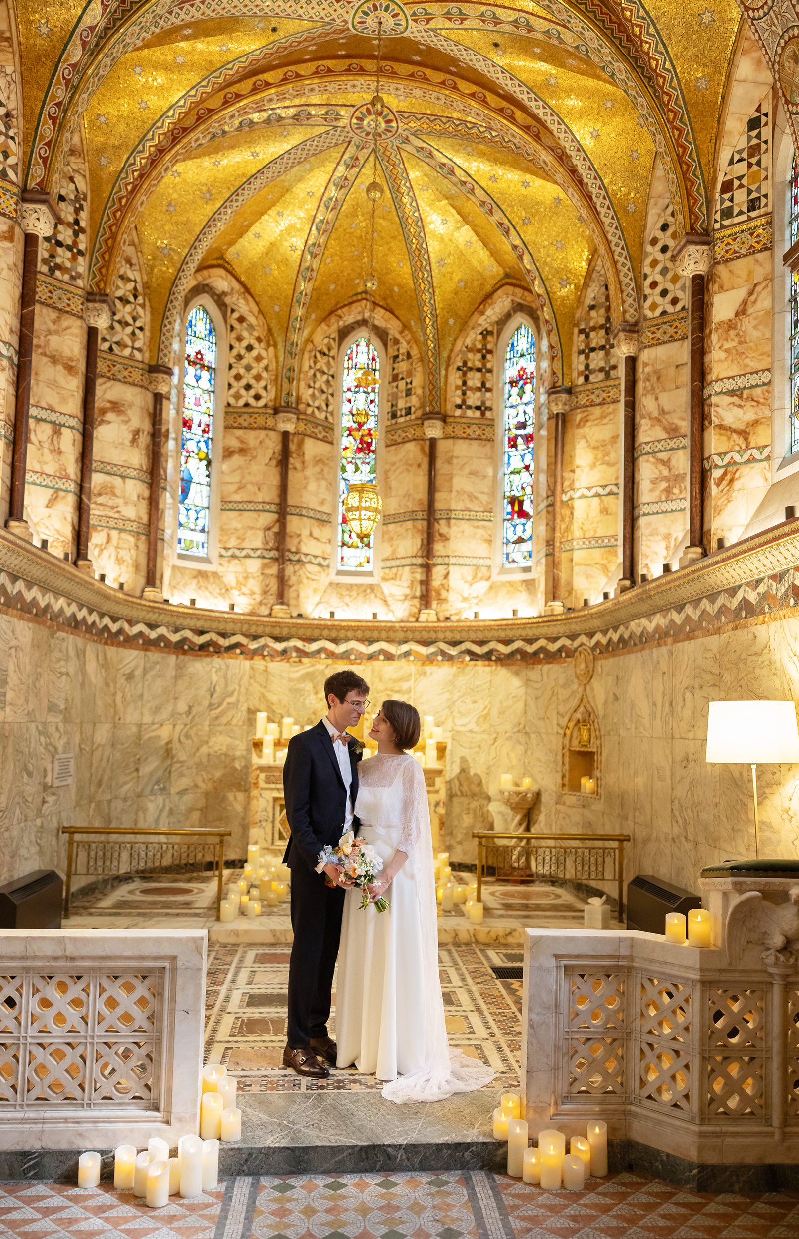 Bride and groom pose inside Fitzrovia Chapel near altar