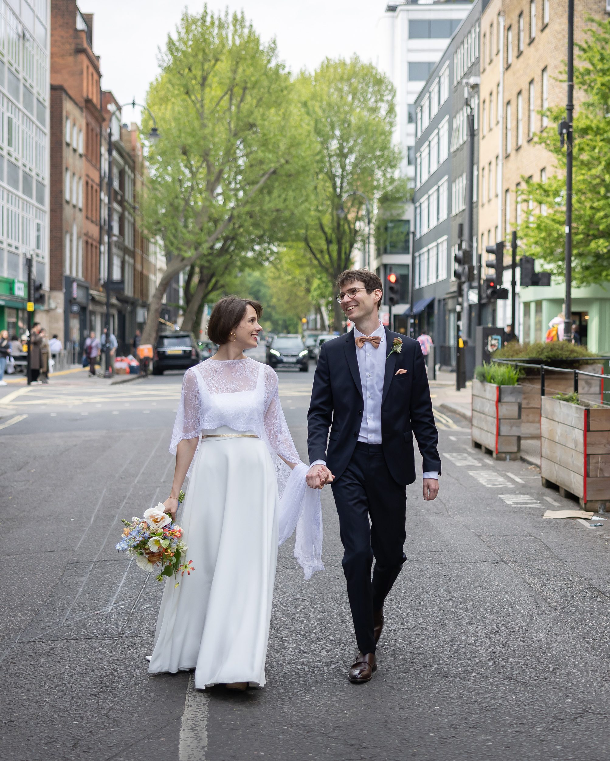 Bride and groom walk down Charlotte Street London