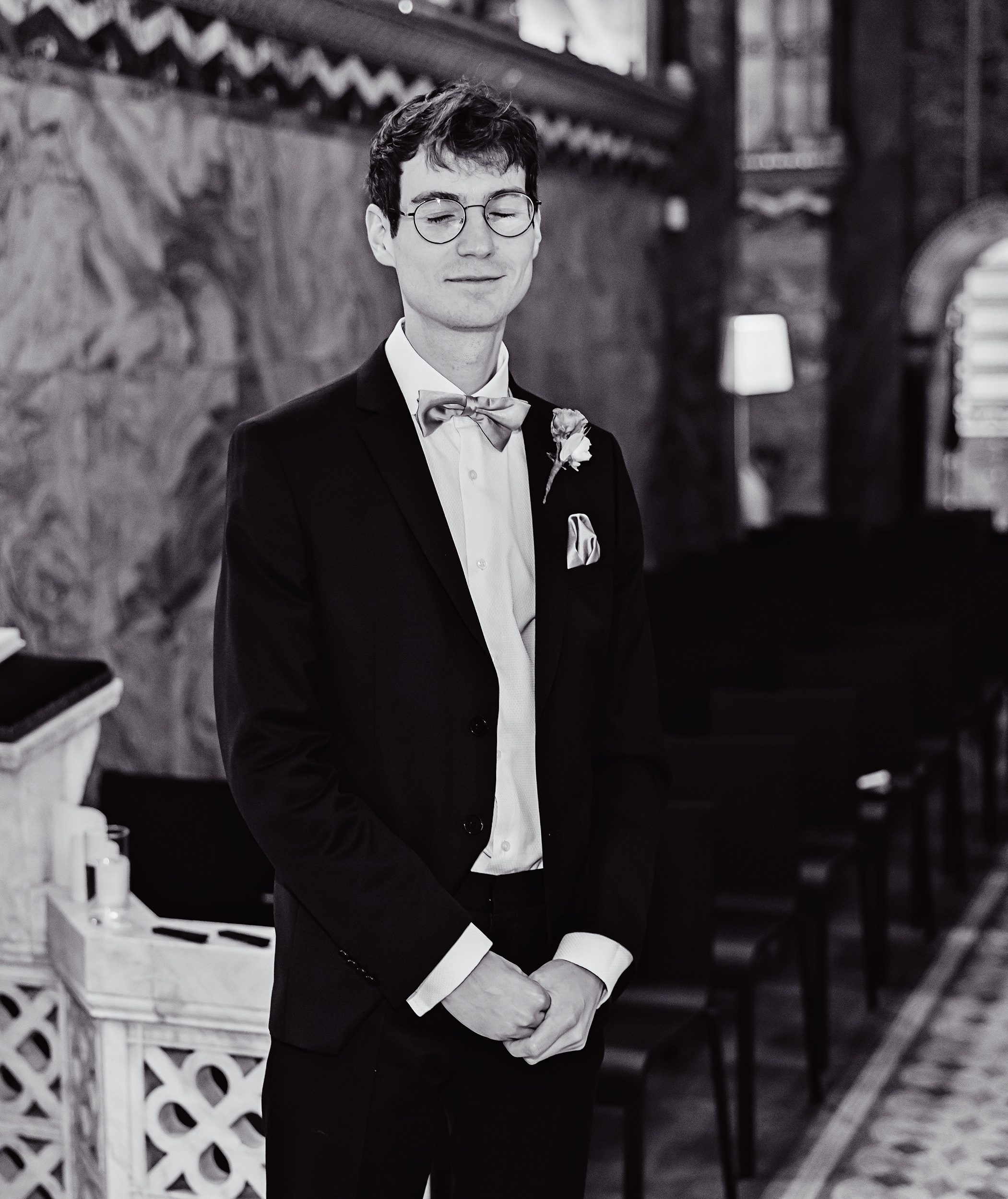 Groom waits eyes closed Fitzrovia Chapel wedding ceremony