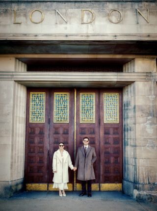 London wedding couple hold hands by old Thames fire station doors