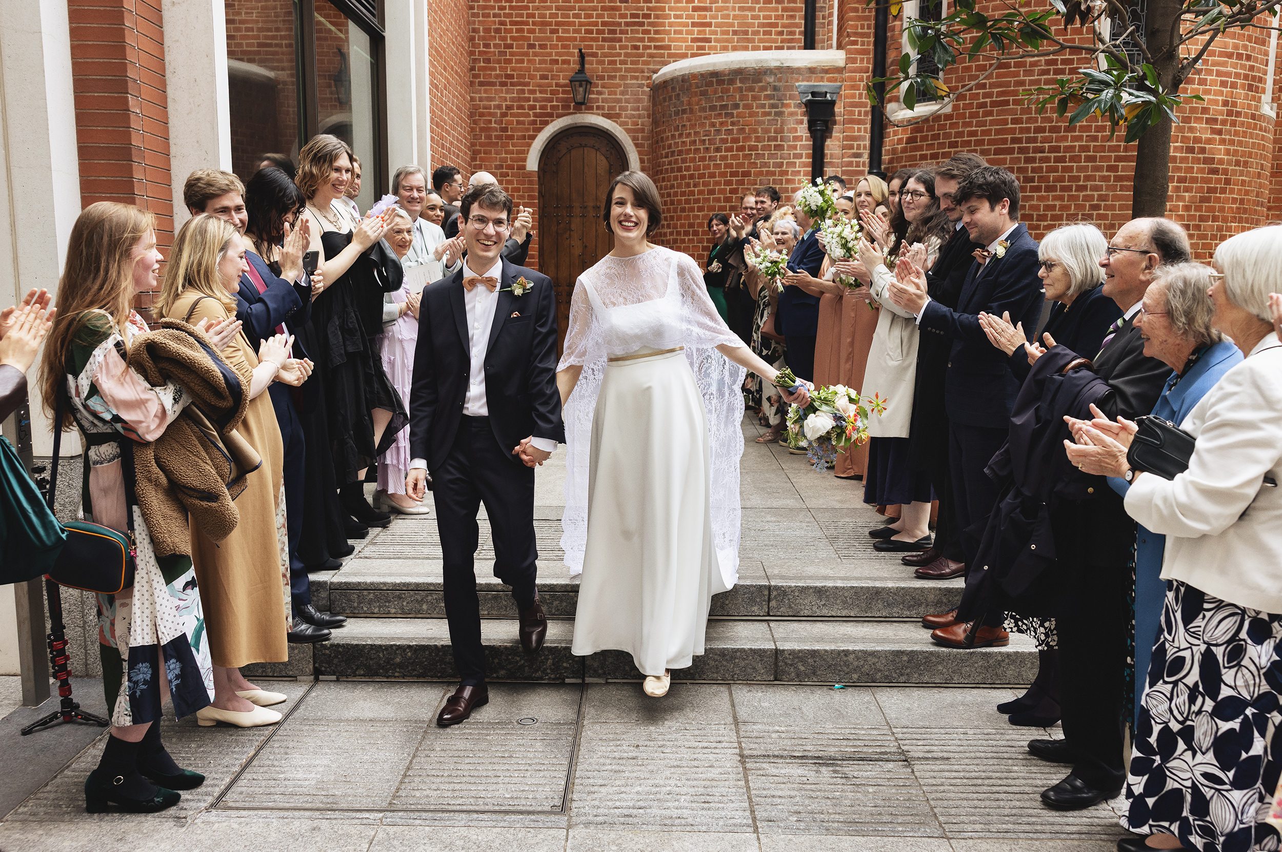 Wedding party applause outside Fitzrovia Chapel central London