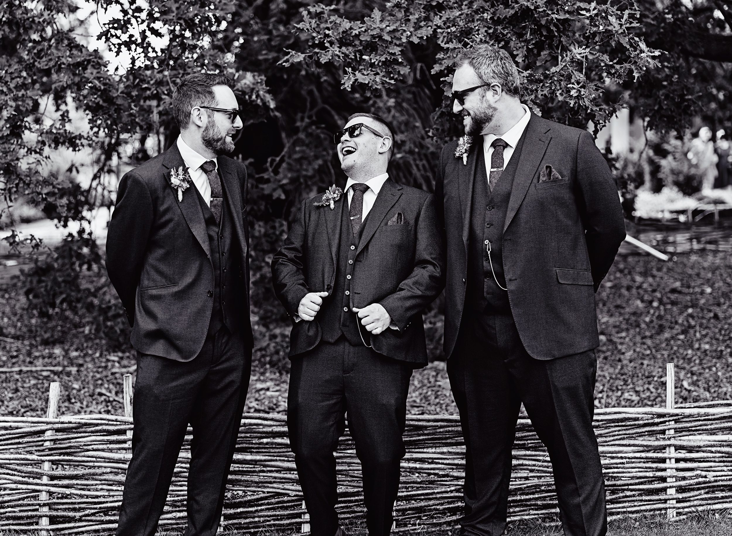 Groomsmen laughing in gardens of Pembroke Lodge Richmond