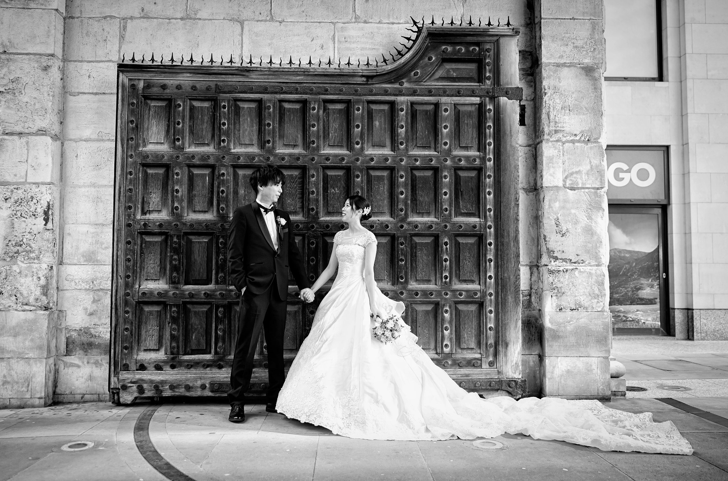 Wide shot bride and groom by gate St Pauls London