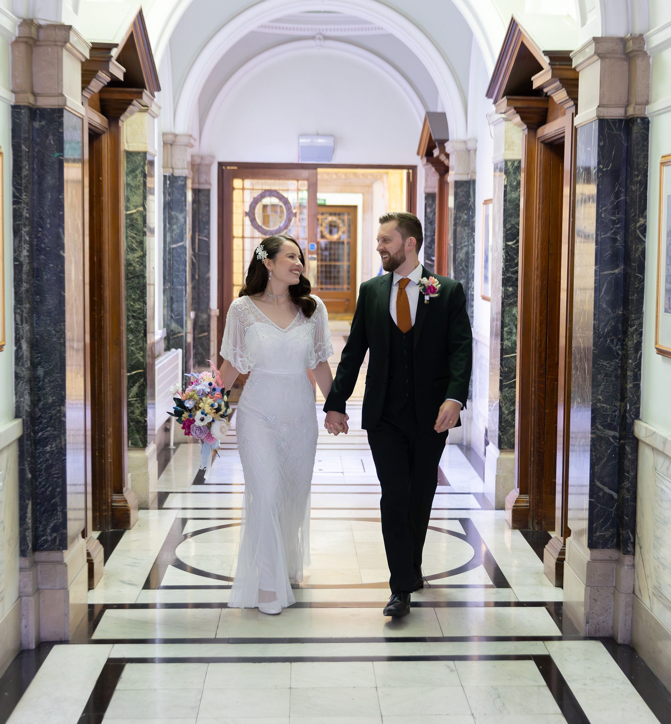 Bride and groom walking down Islington Town Hall corridor